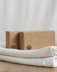 Cork Yoga Bricks on top of white yoga blanket